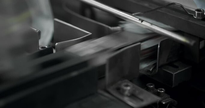 Close up of Manufacturing line at medical factory. Robotic arm put medicine package on conveyor belt. Packaged goods at automated production line. Production line of pharmaceutical manufacturing.