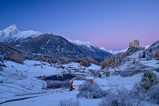 Castle of Tarasp and lake near Sesvenna Alps at dawn, Lower Engadine, Engadine, Grisons, Switzerland