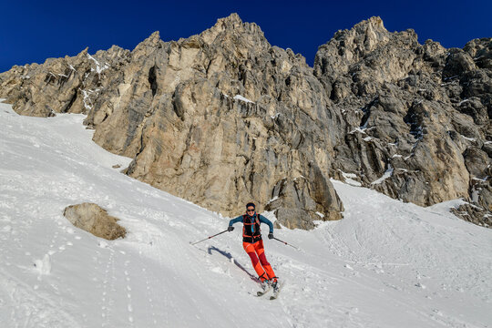 Mature woman back country skiing downhill from Hoelltoerl, Gruenstein, Mieming Range, Tyrol, Austria