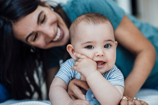 Cute baby girl with happy mother at home