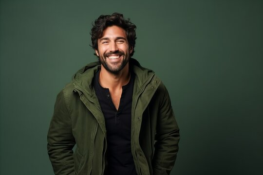Portrait of a handsome man smiling at camera isolated over green background