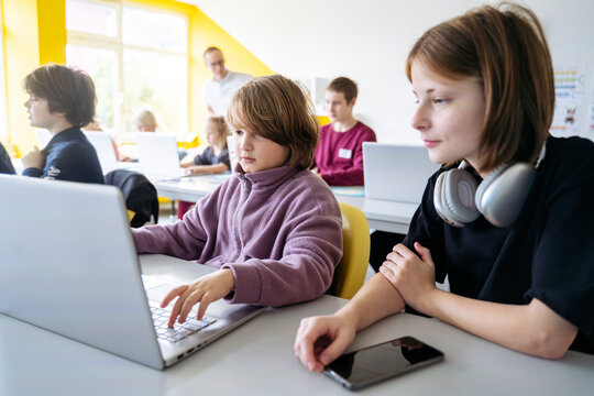 Students learning computer coding in classroom
