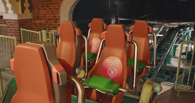 chairs on a rollercoaster trailer. rollercoaster rails. Bright orange armchairs.