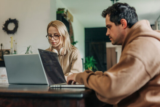 Software programmers working on laptop at home office
