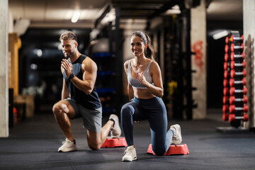 Muscular sporty friends doing lunges in a gym.