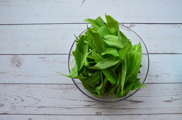 wild garlic, glass bowl, background of herbs and cooking ingredients