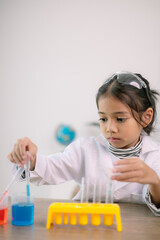 Asian child girl learning science chemistry with test tube making experiment at school laboratory. education, science, chemistry, and children's concepts. Early development of children.