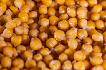 A close up of a large pile of yellow chickpeas