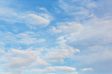 Morning sky. Beautiful fluffy clouds painted in pastel painterly colors at sunrise. Multicolor background or wallpaper