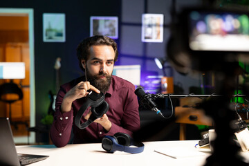 Audiophile reviewing newly launched wireless headphones, testing sound clarity before endorsing them. Tech expert filming internet channel video, checking listening device features
