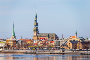 Fototapeta premium Riga towers and rooftops day time skyline. Sunny spring time shade on the buildings in Riga, next to a market and new project of railway in the Baltic States