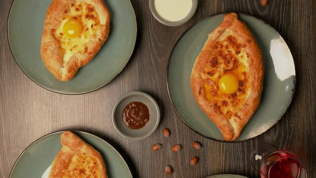 Adjarian khachapuri in a home-cooking restaurant. Food b roll. Georgian cuisine traditional food, homemade cooking. Khachapuri with eggs.