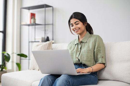 Young woman using laptop computer at home. Student girl working in her room. Work or study from home, freelance, casual business, lifestyle concept