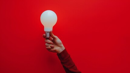 Close-up of a bright light bulb hand held