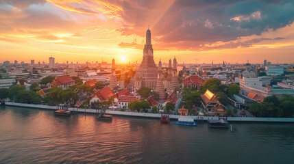 A panoramic view of Wat Arun temple at sunset in Bangkok, Thailand with the river and city in the background