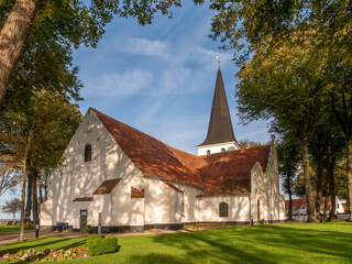 Fototapeta na wymiar Saint Nicholas Church amid autumn trees in old town of Bogense, Funen, Denmark