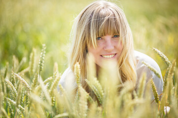 Naklejka na ściany i meble beautiful girl in a linen dress in a wheat field