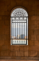 window with semicircular arch and wrought iron grille with Christian religious decoration