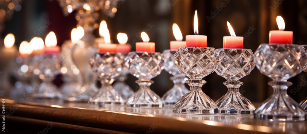 Poster an arrangement of red candle holders with candles on a rectangular glass table at an event, creating