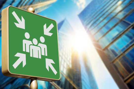 Emergency assembly point. Green sign in a city against a clear blue sky. Outdoor sign indicating where people should congregate following an emergency evacuation of the building. Generative Ai.