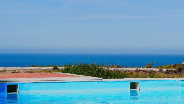 Serene pool overlooking a vast blue sea on summer bright day