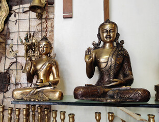 Decorative metal figurines of Buddha in a meditative pose on a shop window