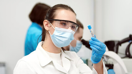 A scientist in a modern laboratory studies samples and conducts experiments. Microbiology, pharmaceutical biochemistry, medical technology. Working on vaccines and medicines in a team of specialists.