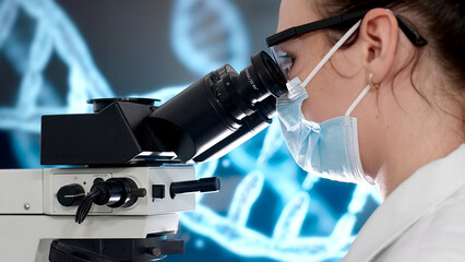 In a modern medical laboratory: a microbiologist looks under a microscope, analyzing a sample. A...