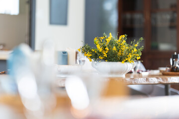 A table with a vase of yellow flowers in the center