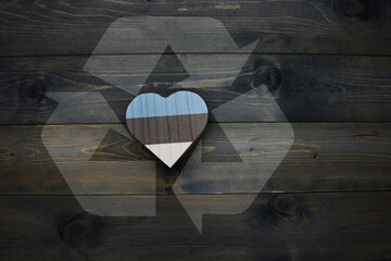 wooden heart with national flag of estonia near reduce, reuse and recycle sing on the wooden...