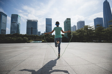 Fitness woman jumping rope at city