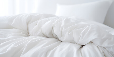 Fototapeta na wymiar White bedding including pillows duvet and duvet cover on a disheveled bed 