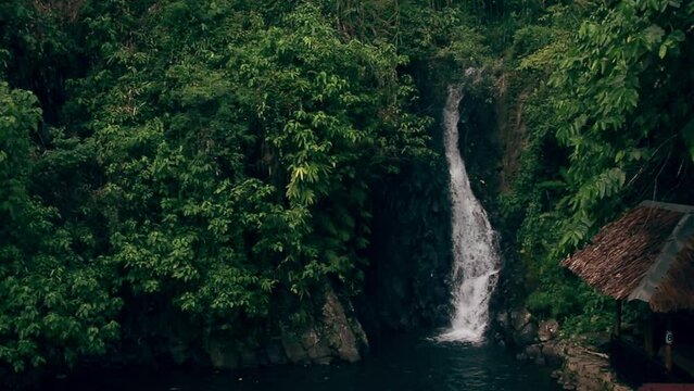 Ambient motion of cascading water among the green lush tropical jungle foliage in PulangBato Waterfalls, a popular tourist destination in Valencia, Negros Oriental Philippines