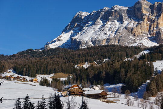 Idyllic dolomite village during winter with snow covered mountains in Alta Badia at nature park Fanes-Sennes-Prags, Abtei, Badia, South Tirol, Italy