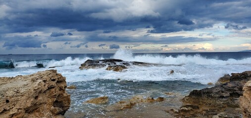 Waves crashing in the Mediterranean sea as storm approaches over the horizon