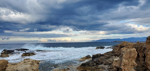Waves crashing in the Mediterranean sea as storm approaches over the horizon