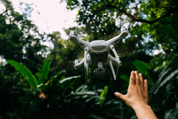 White drone with camera flying in summer mountains