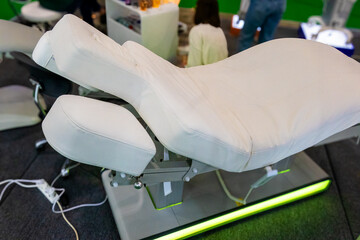 White chair for cosmetic procedures with electrically adjustable tilt and height.