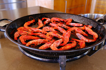 Cooking shrimp in a frying pan. Roasting shrimp for paella.