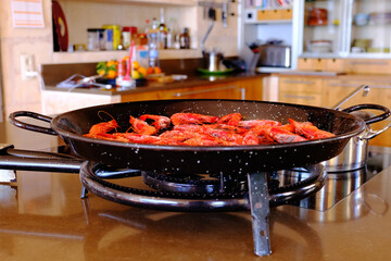 Cooking shrimp in a frying pan. Roasting shrimp for paella.