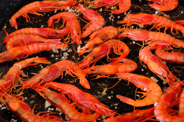 Cooking shrimp in a frying pan. Roasting shrimp for paella.