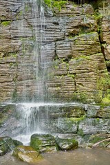 Water cascading onto moss covered rocks.