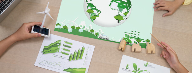 Green city poster was placed on green business meeting room. Professional architect hand holding...