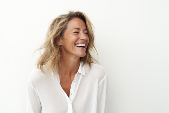 Portrait of a happy mature woman laughing against a white background.