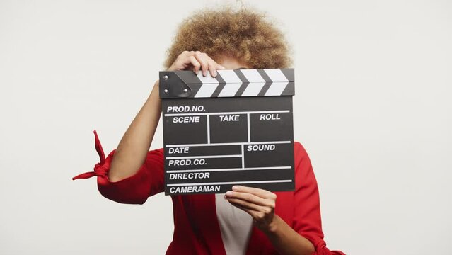 Woman Looking Through Clapperboard against White Background