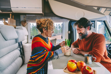 Youth mature couple enjoy life in a camper van motorhome together in indoor leisure activity....