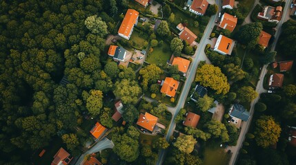 An aerial view of a residential neighborhood with orange rooftops. The homes are surrounded by lush green trees. - obrazy, fototapety, plakaty