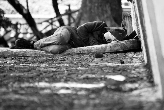 Black and white man sleping in the street - Powered by Adobe