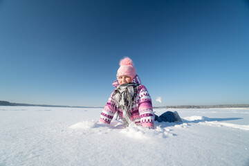 Fototapeta na wymiar girl in a pink hat with a pompom, winter, snow