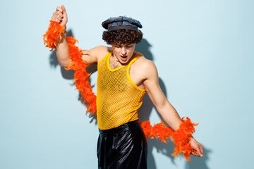 Side view young fun happy gay Latin man wear mesh tank top hat yellow clothes tinsel dance isolated...